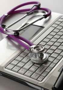 A violet stethoscope on a white laptop computer